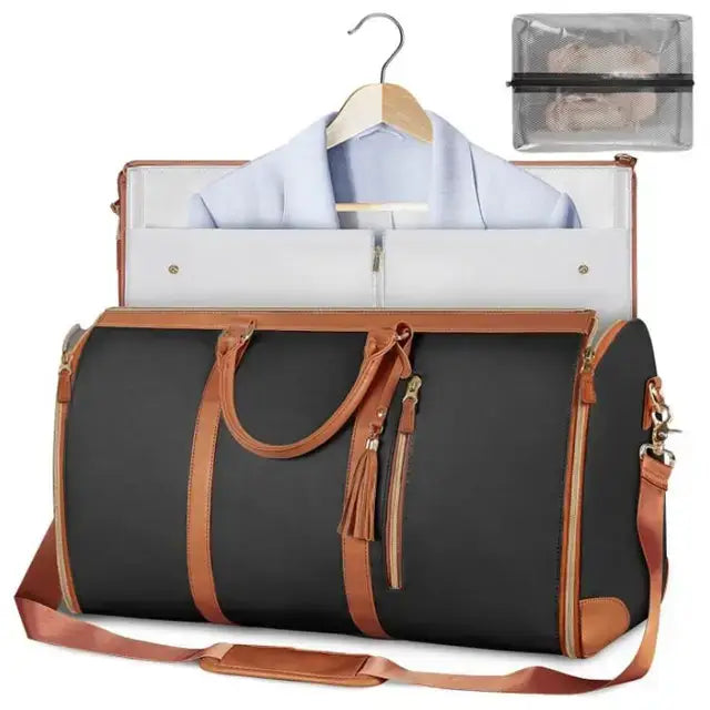 VoyageVault Carry-On foldable duffel bag in black with brown straps, featuring garment holder and transparent accessories pouch.